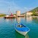A tranquil harbor with small fishing boats near a medieval village